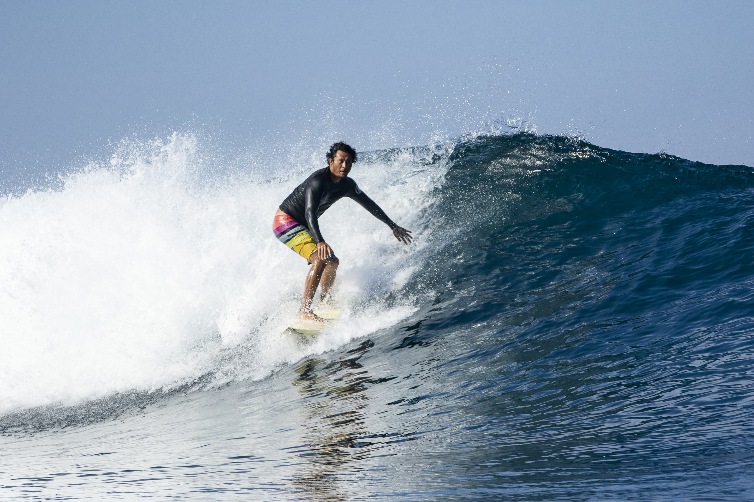 Surfer carving across a wave during a Bali Kami surf trip